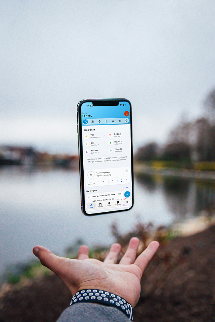 Person holding phone with Best Life app over a lake